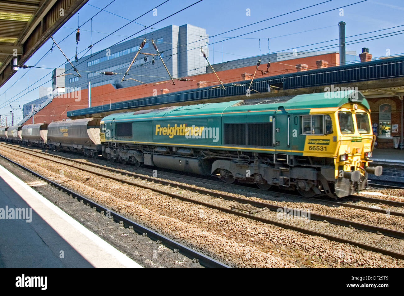 Coal train hauled by a class 66 diesel locomotive on the East Coast mainline at Doncaster station Stock Photo