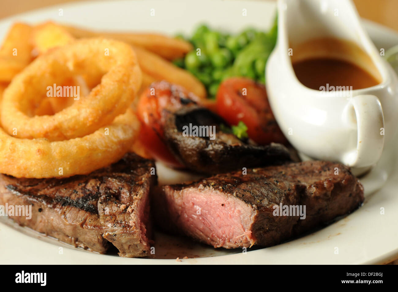 Traditional pub food sirloin steak, onion rings and peas Stock Photo Alamy