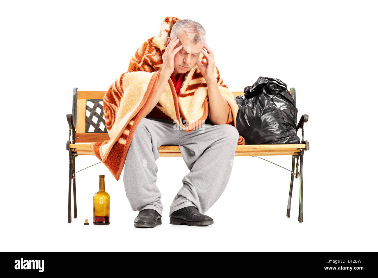 Disappointed homeless mature man sitting on a wooden bench Stock Photo