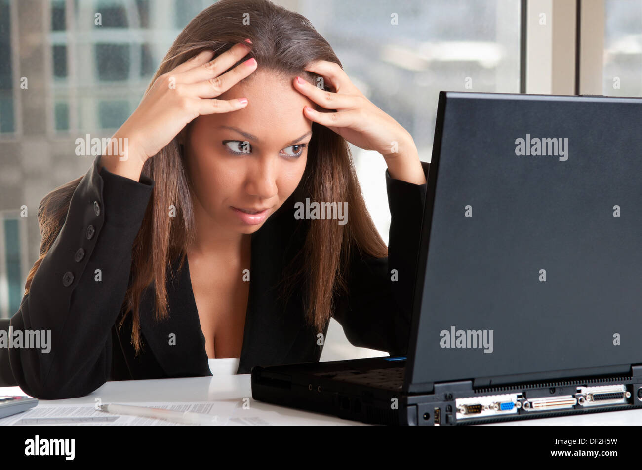 Worried businesswoman looking at a computer screen in an office Stock Photo