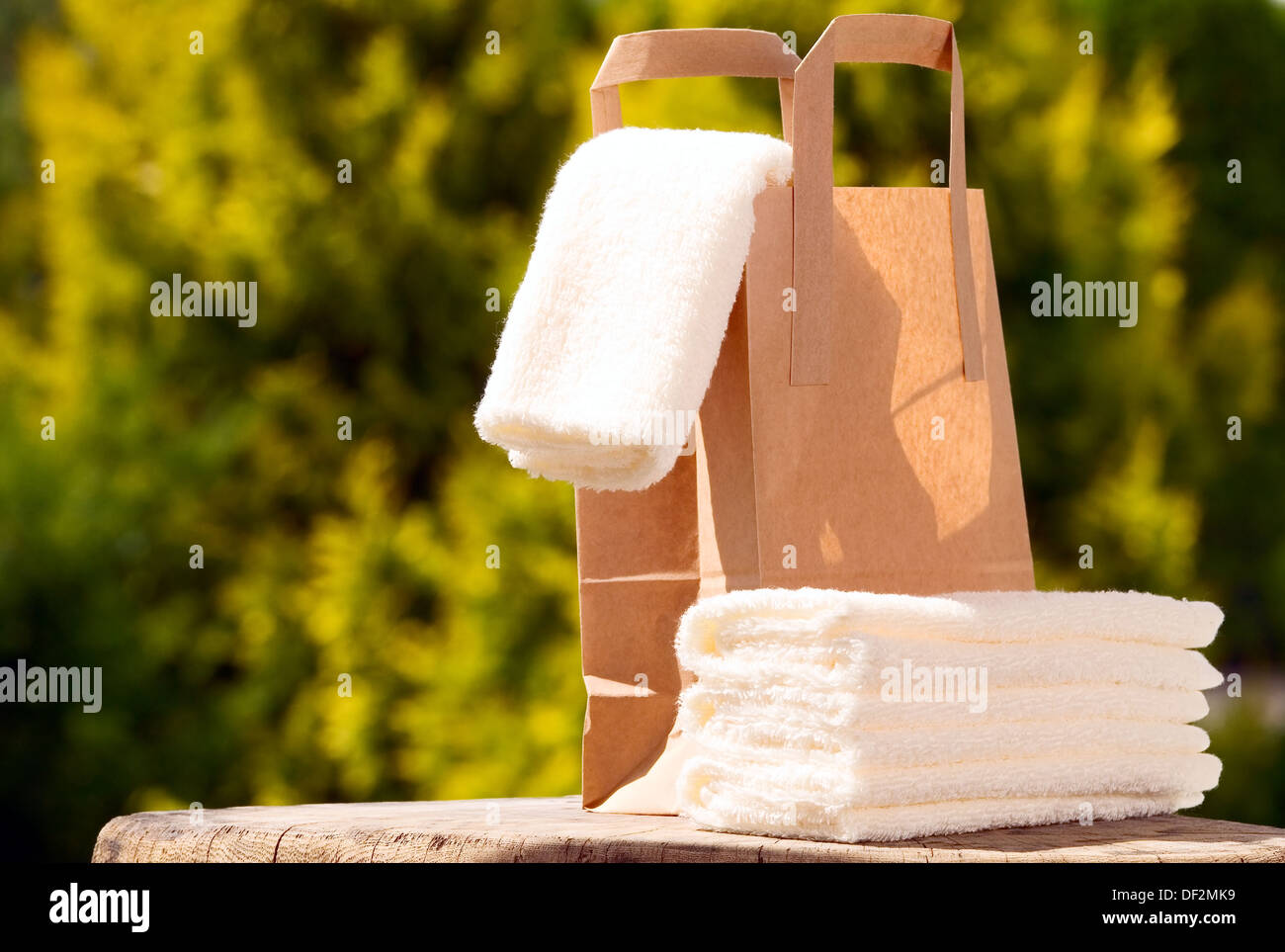 White towels with paper bag on green background Stock Photo