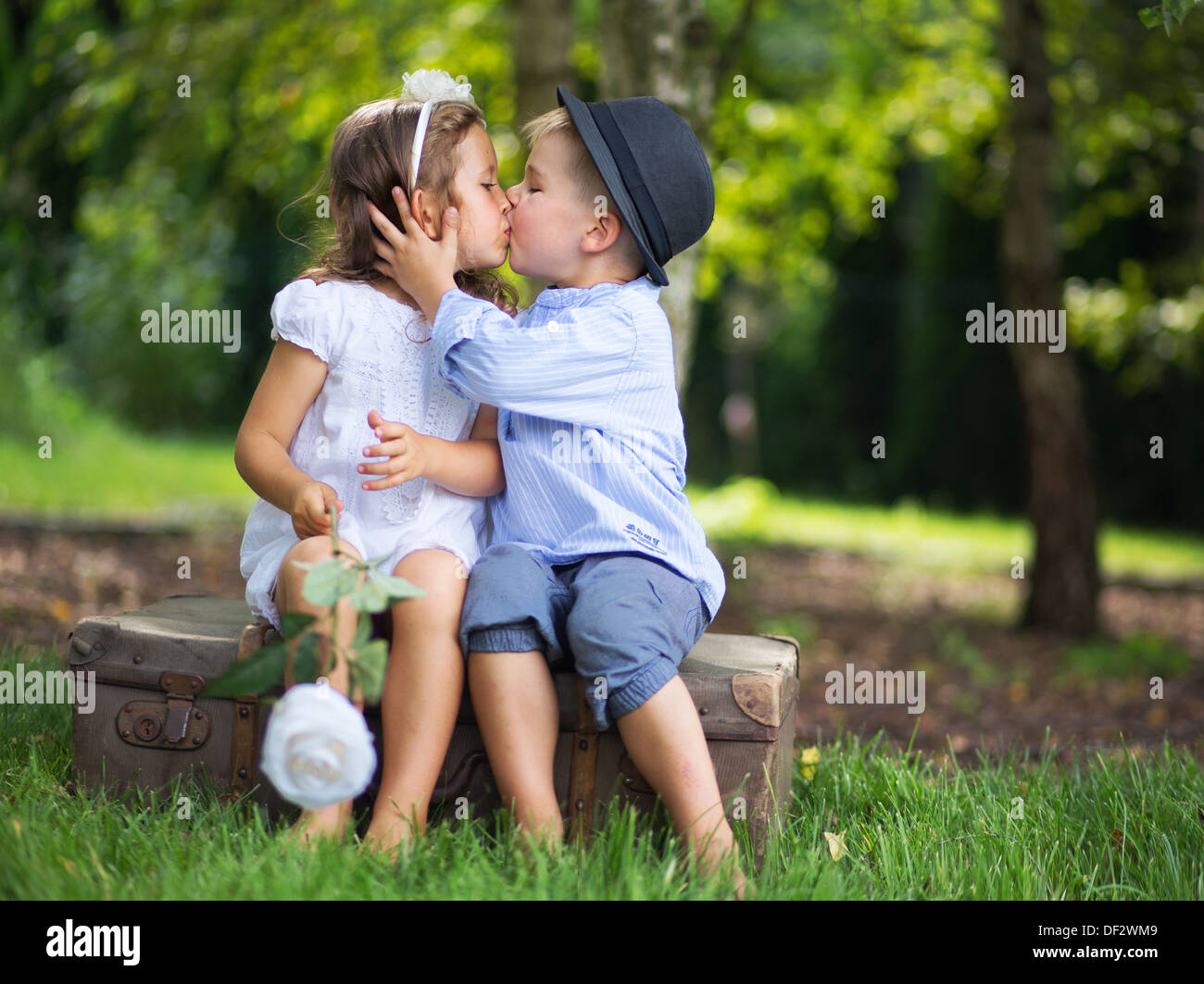 Cute couple of kids kissing each other Stock Photo - Alamy
