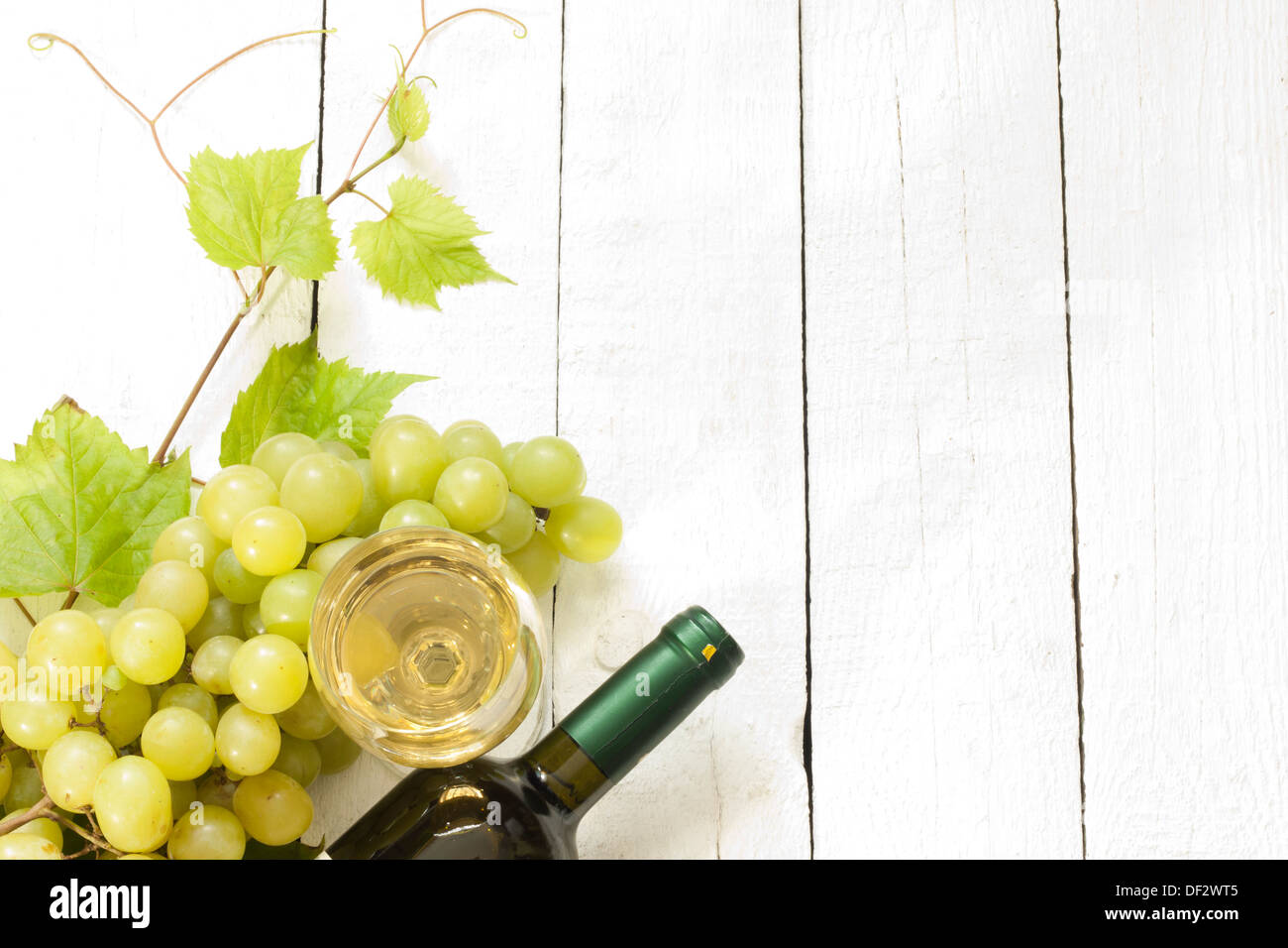 Glass of white wine with bottle and grapes on vintage boards Stock ...