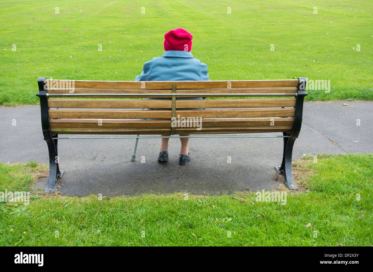 Ninety year old lady alone on park bench. UK Stock Photo