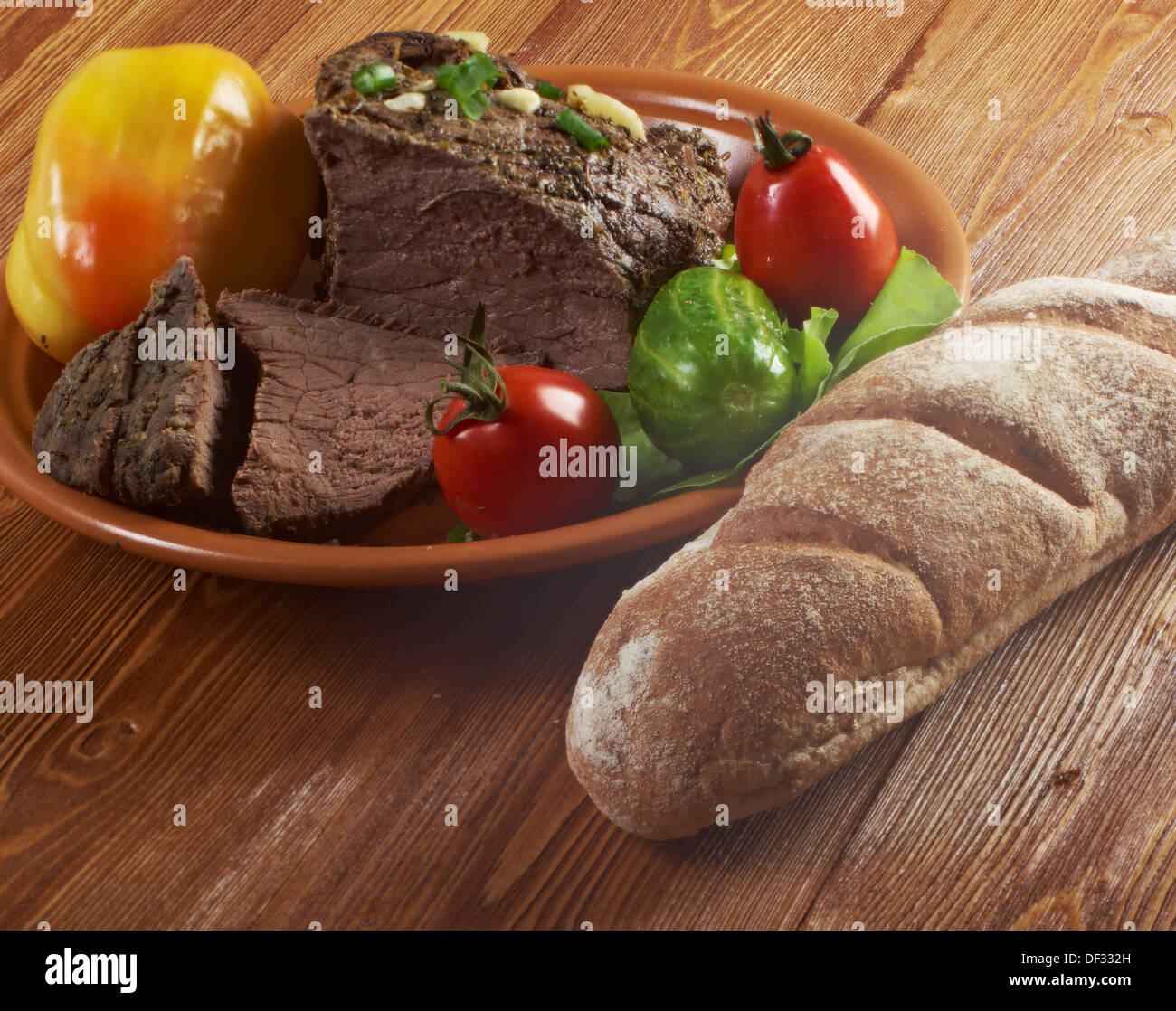 roast beef farm-style with vegetable and bread .farmhouse kitchen Stock Photo