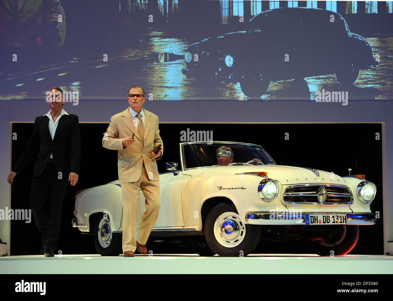 Bremen, Germany. 26th Sep, 2013. An actor (R) of 'tehatre du pain' plays the role of car manufacturer Carl C.W. Borgward in front of a Borgward Isabella Cabrio of the 1950s at the anniversary '35 years of Mercedes-Benz car production and 75 years of production hall Bremen' at the pressing plant of Daimler in Bremen, Germany, 26 September 2013. The automobile plant was founded 75 years ago by Carl F.W. Borgward and 35 ago Mercedes-Benz started producing at the site. Photo: Ingo Wagner/dpa/Alamy Live News Stock Photo
