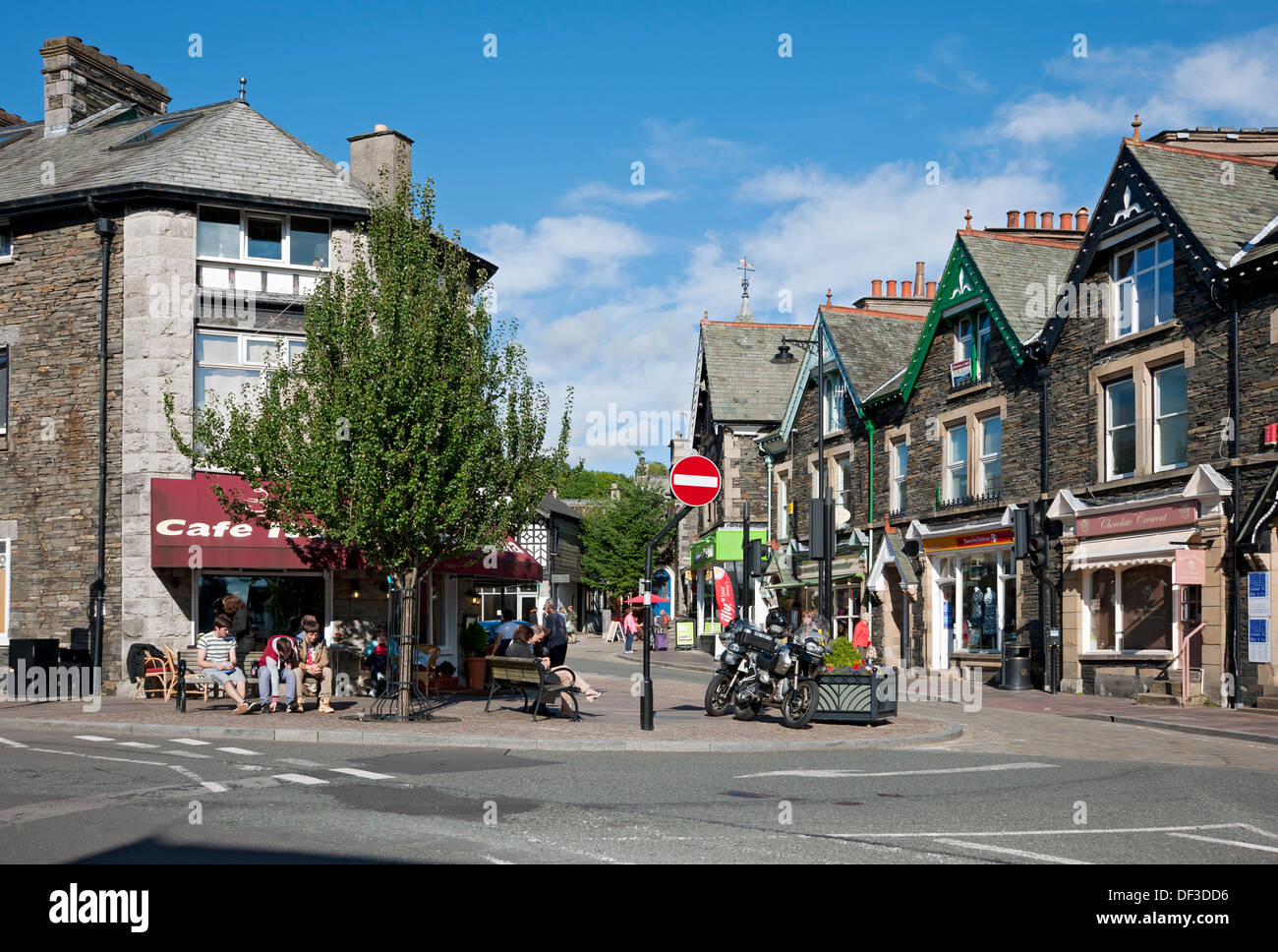 People tourists visitors outside shops stores businesses in the town centre in summer Windermere Cumbria England UK United Kingdom GB Great Britain Stock Photo