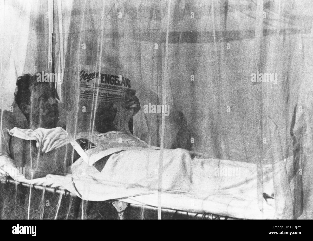 The image from the Nazi Propaganda! depicts a soldier of the German Wehrmacht lying in his tent under a mosquito net reading the newspaper - 'Against England' is the headline - in Africa, published on 18 June 1942. Place unknown. Fotoarchiv für Zeitgeschichte Stock Photo