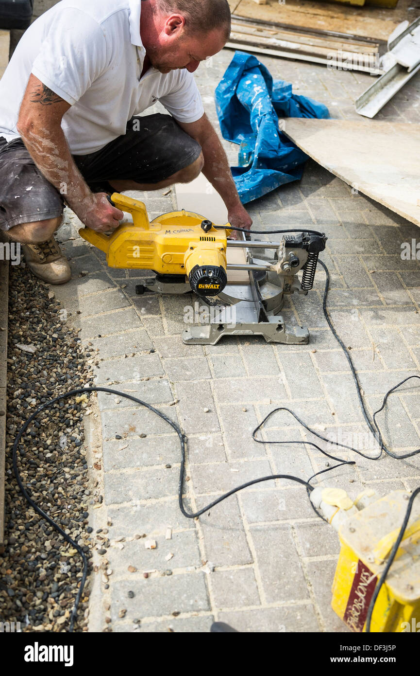 A builder using a chop saw to cut a piece of wood Stock Photo Alamy