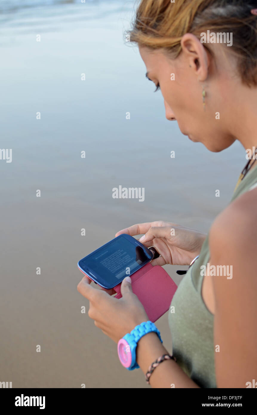 Young woman using mobile telephone on the beach Stock Photo Alamy