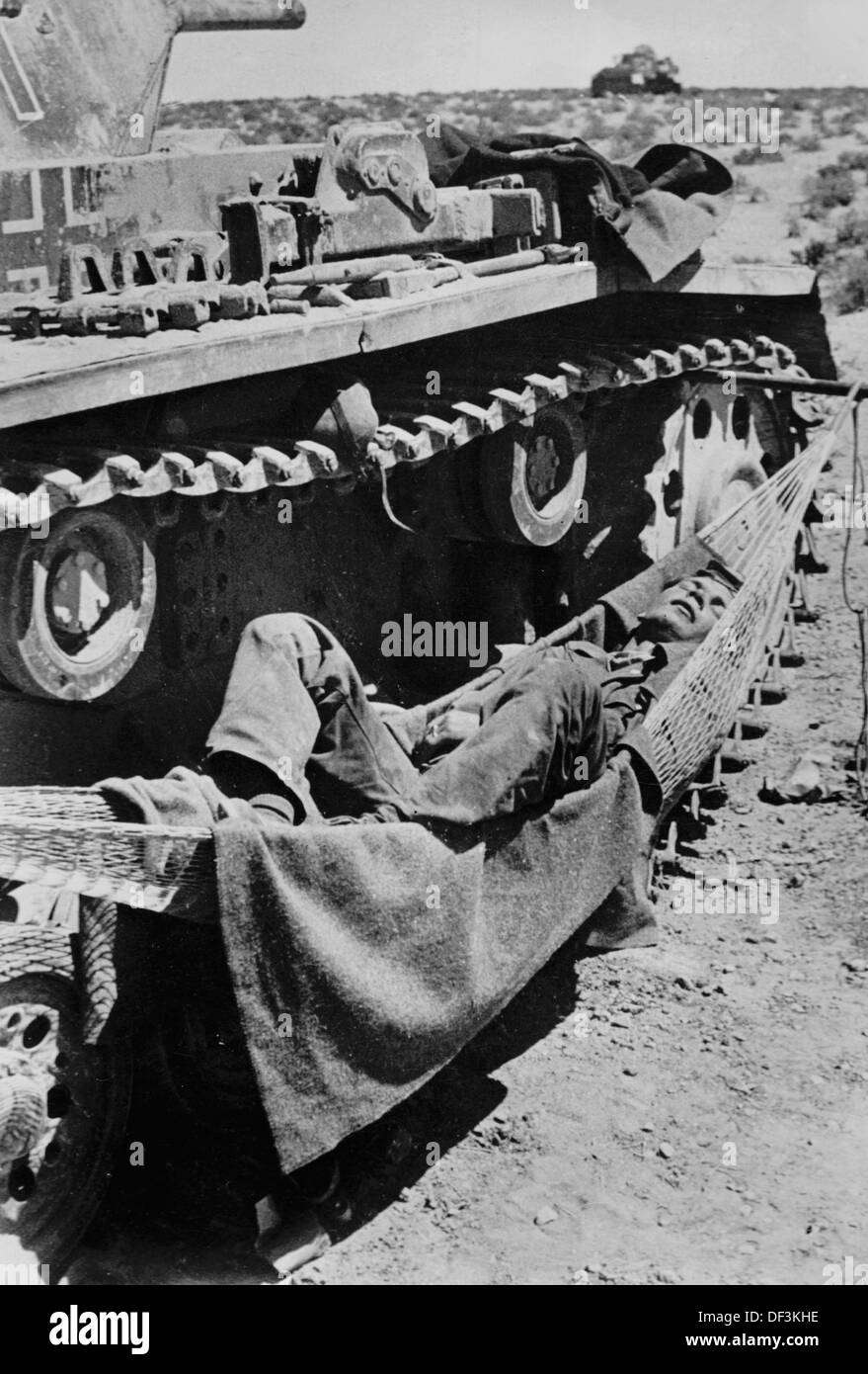 The image from the Nazi Propaganda! depicts a soldier of the German Wehrmacht resting in a hammock that is attached to a tank in Africa, published on 25 May 1941. Place unknown. Fotoarchiv für Zeitgeschichte Stock Photo