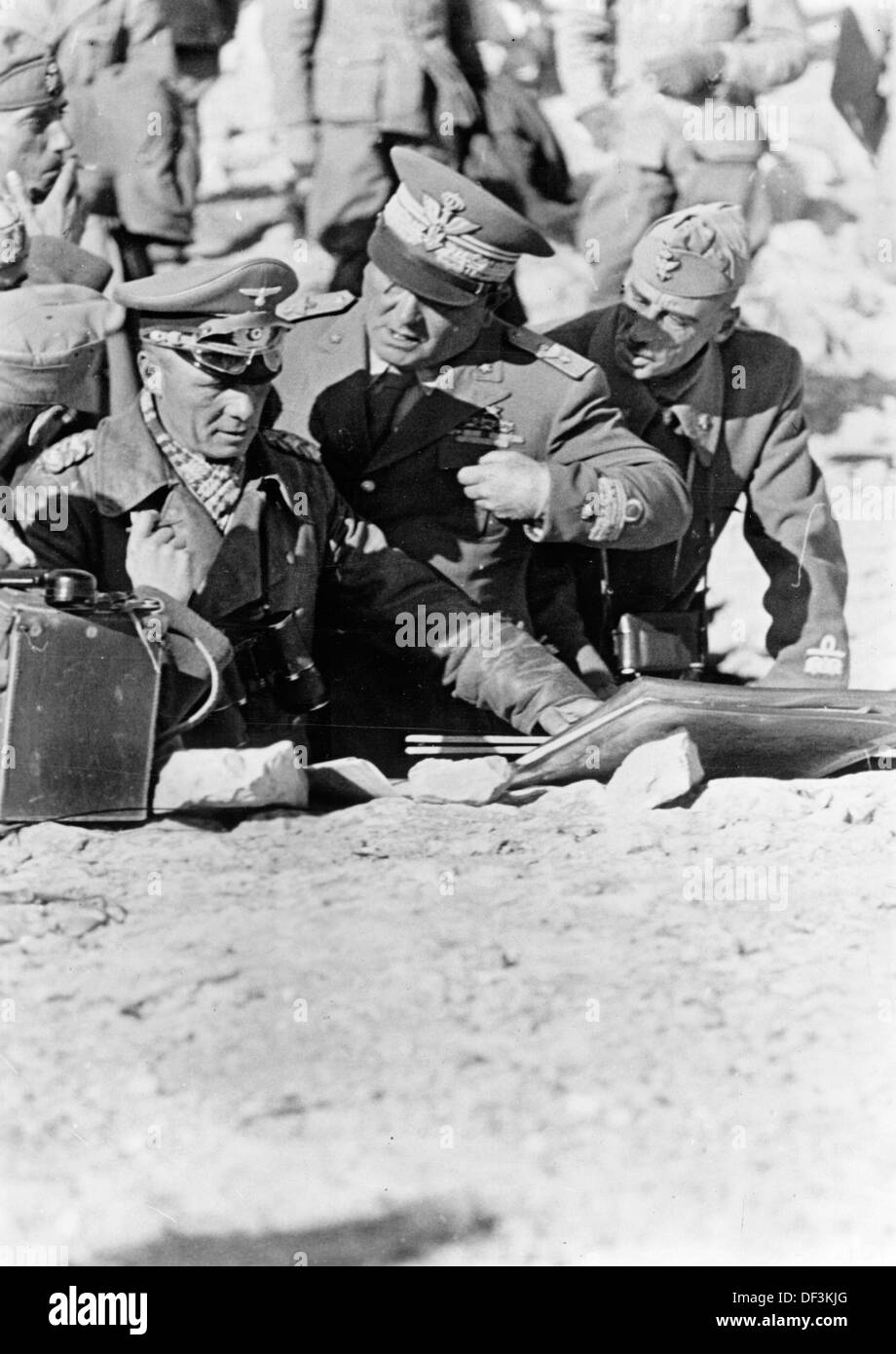 Field Marshal Erwin Rommel (l) talks with Italian allies in the field during the occupation of Tobruk in July 1942. The Nazi Propaganda! on the back of the image is dated 4 July 1942: 'Field Marshal Rommel during strategic planning in the desert in North Africa. Field Marshal Rommel talks to the Italian Chief of Staff Cambara (m) and General Calvi (r) about the employment of German and Italian troops to follow the fleeing enemy on the Egyptian border.' Fotoarchiv für Zeitgeschichte Stock Photo