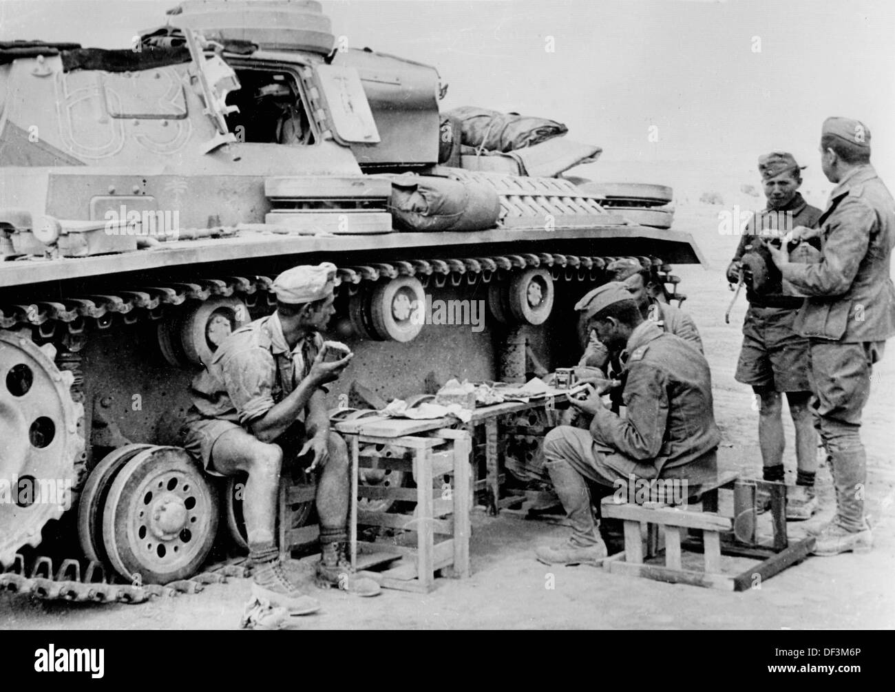 The image from the Nazi Propaganda! depicts soldiers of the German Wehrmacht eating next to a tank in Sallum, Egypt, published on 30 June 1941. Fotoarchiv für Zeitgeschichte Stock Photo