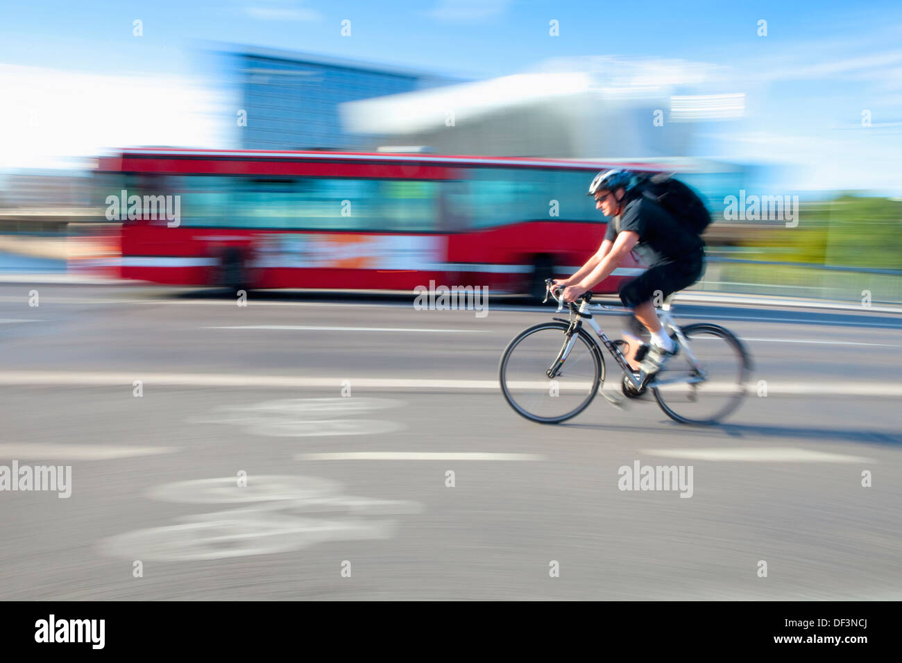 Sweden, Stockholm - bicyclist in a bike lane and a public transport bus. Stock Photo