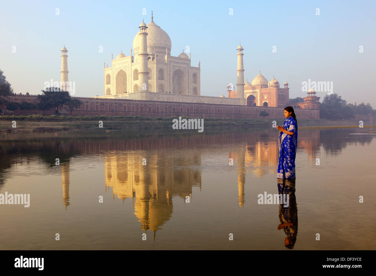 India, Uttar Pradesh, Agra, Woman wearing blue sari standing next to the Taj Mahal Stock Photo
