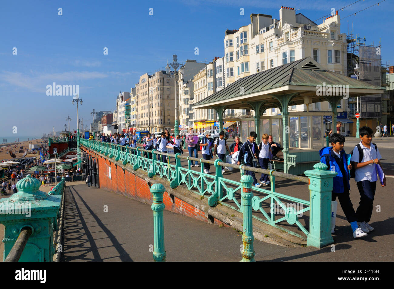 Brighton, East Sussex, England, UK. Hotels and shelter on the seafront. Schoolchildren walking past Stock Photo