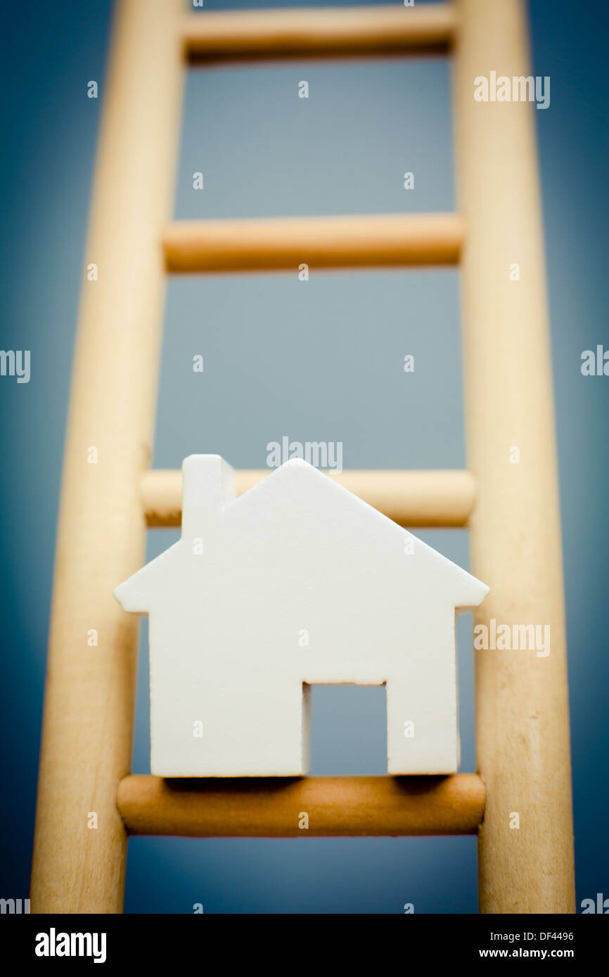 Model House On Rung Of Wooden Ladder Stock Photo