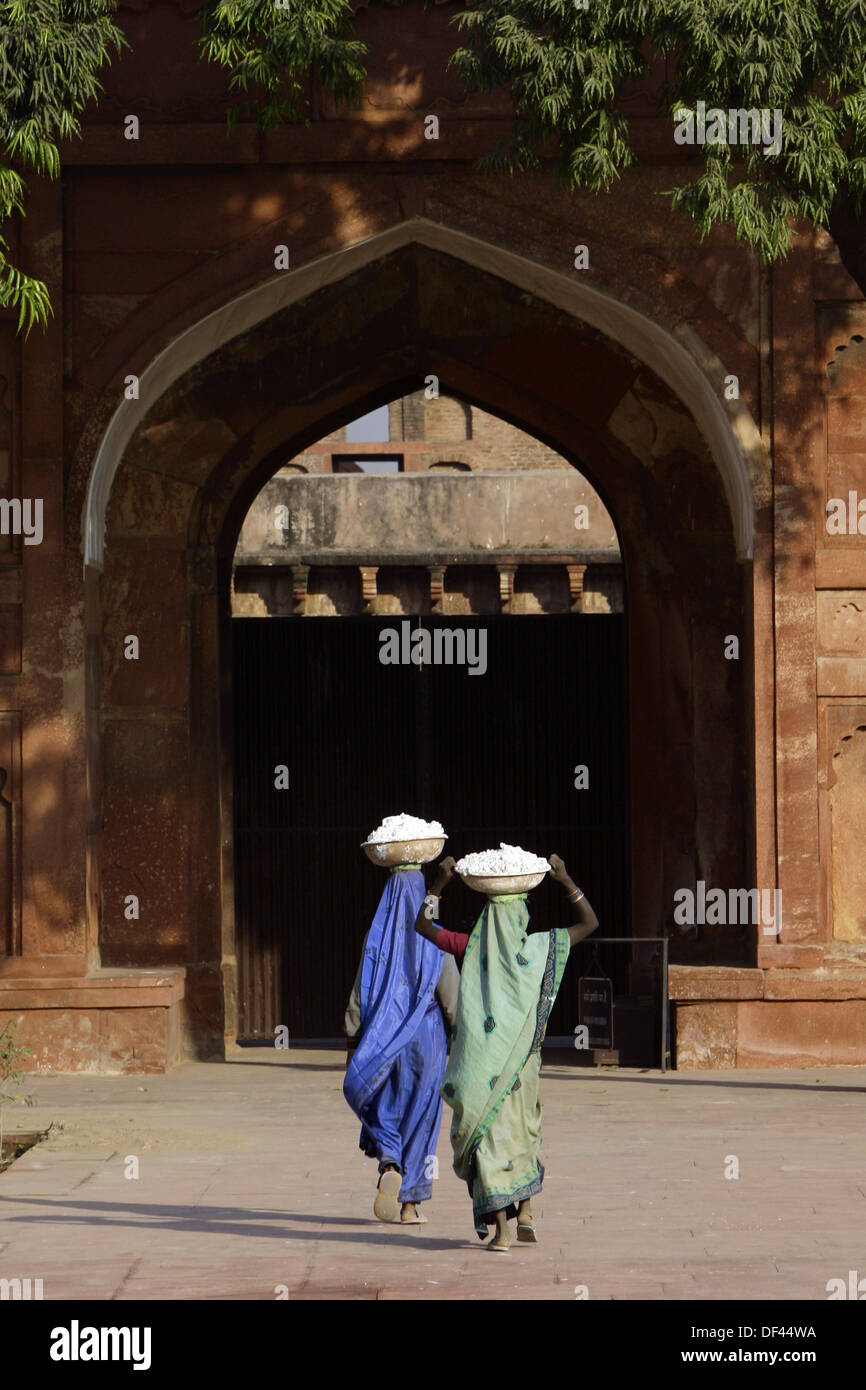 Ladies carrying baskets on heads inside Red fort complex India Uttar Pradesh Agra Stock Photo