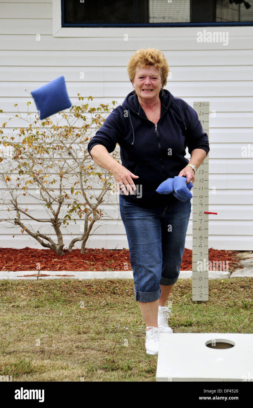 Female Senior retired citizens play game of bean bag toss in a recreational vechile camping park