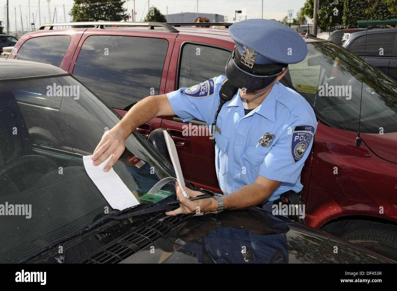 Police officer writes a ticket for parking violation Stock Photo