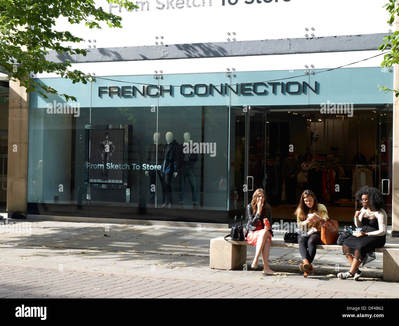 Office workers having lunch in front of French Connection store in Manchester UK Stock Photo