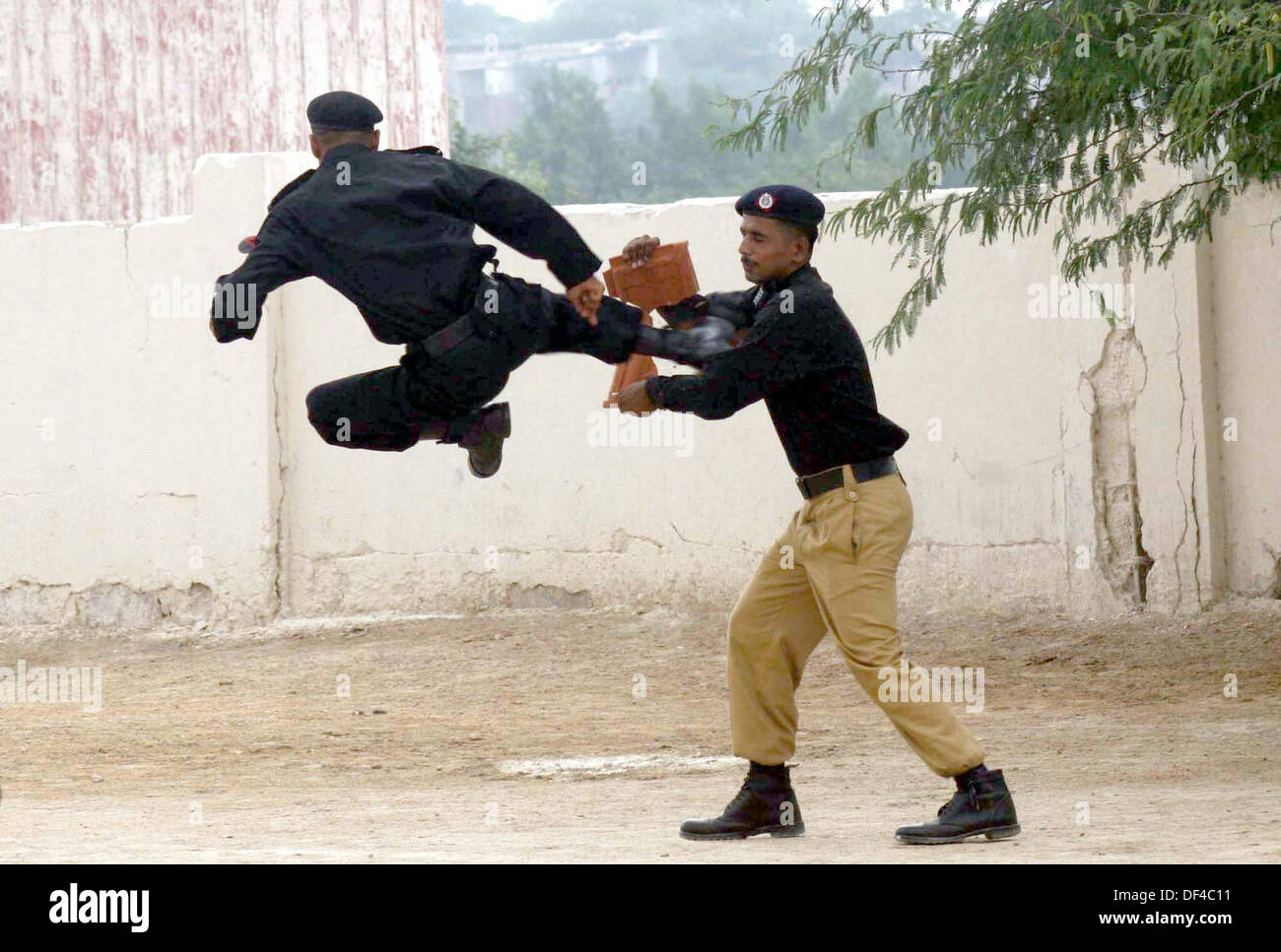 Elite Force Commandos of Police are showing their talent during 28th-29th passing out parade held at Razzaqabad Police Training Center of Karachi on Friday, September 27, 2013. Stock Photo