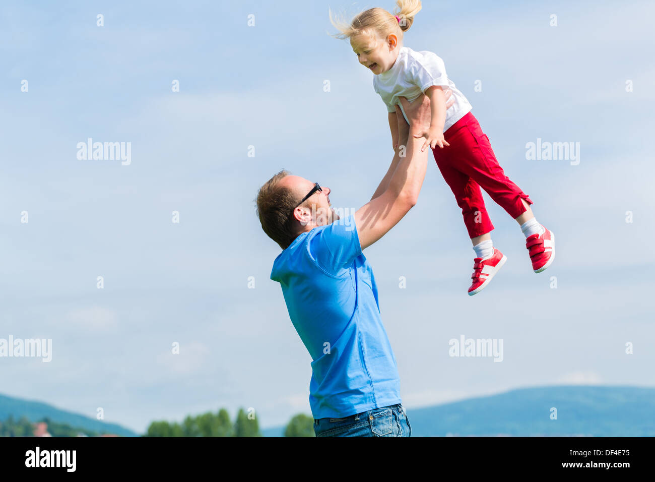 Family Little girl and her father or dad on a meadow in summer Stock Photo