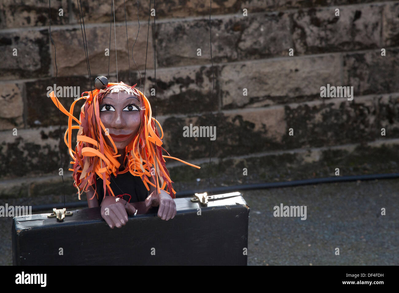 Scary, toy, doll, horror, halloween, spooky female puppet with long orange hair & suitcase at Skipton UK. 27th September, 2013. International Puppet Festival. Puppet NITUNGA at Skipton's biennial international puppet festival featuring puppet theatre companies from all over Europe. Stock Photo