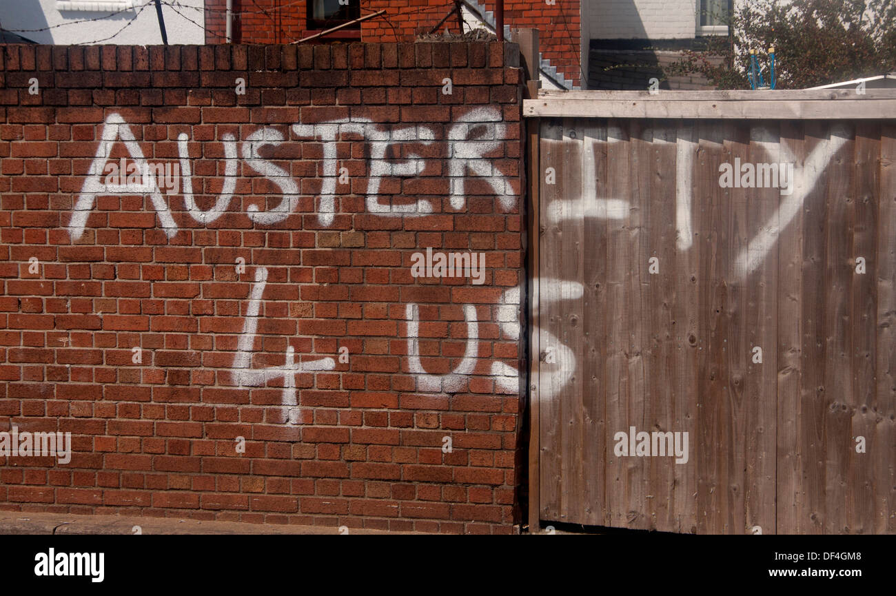 Graffiti condemning economic policy 'Austerity 4 Us' White paint on brick wall Cardiff Wales UK Stock Photo