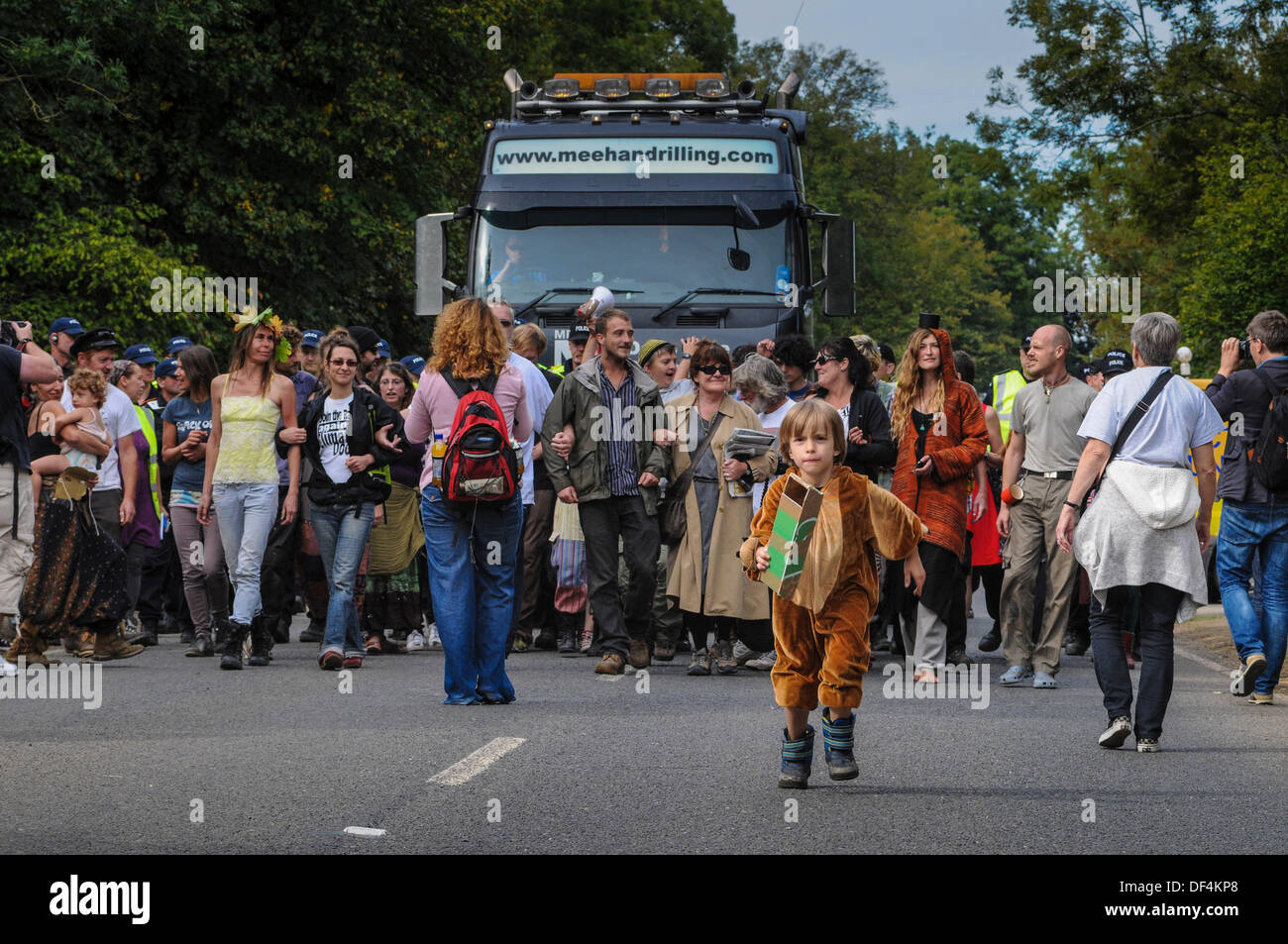 Young environmental protester leads the way as one of the final site clearance lorries is escorted down the road to Cuadrillas entrance. Soon afterwards the site was closed and Police operations stood down. Stock Photo