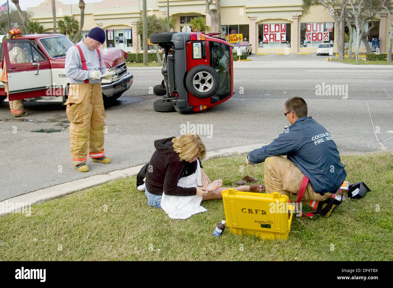Firemen, police, and medical personel assist injured people at automobile accident Stock Photo