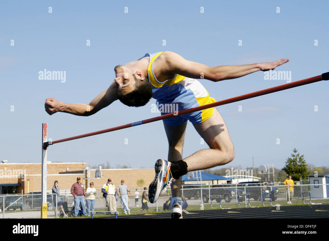 High jumper clears the bar in a high school track competition Stock