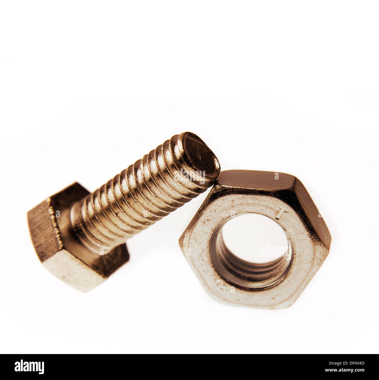 Nut and bolt together on plain background Stock Photo