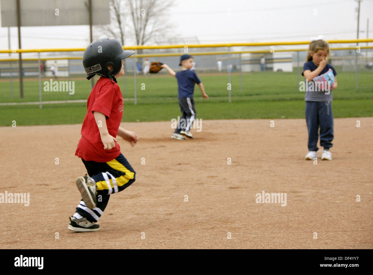 5 year old running wearing a protective helmet and tennis shoes Stock