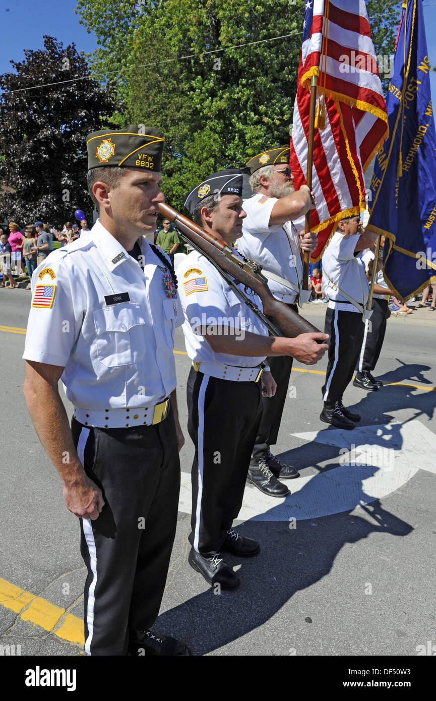 Uniformed Veterans Marching in Parade Honor Guard with Flags Stock