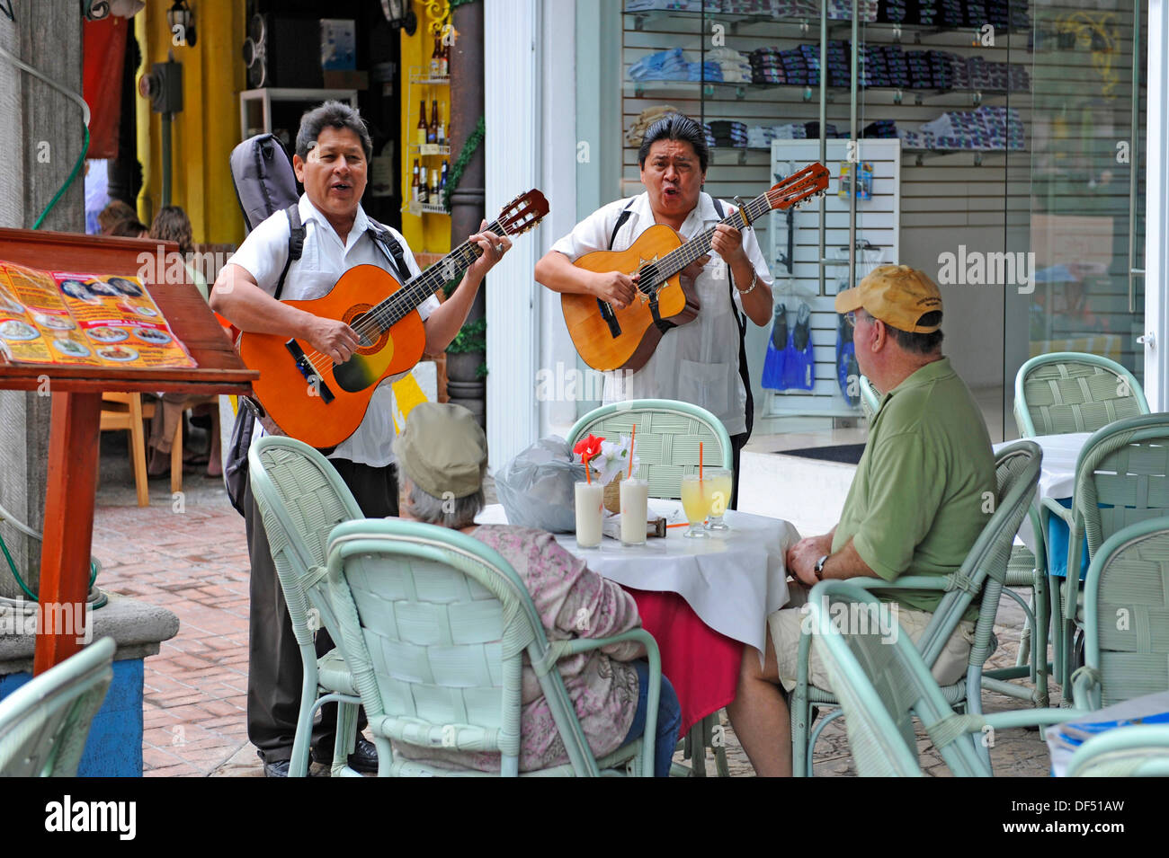 Mexican guitar players and singers entertain patrons at bar restaurant