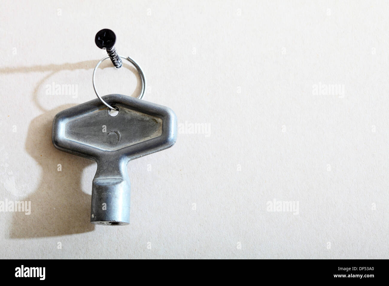 one little winding key used for clock and toys on wall copy space Stock
