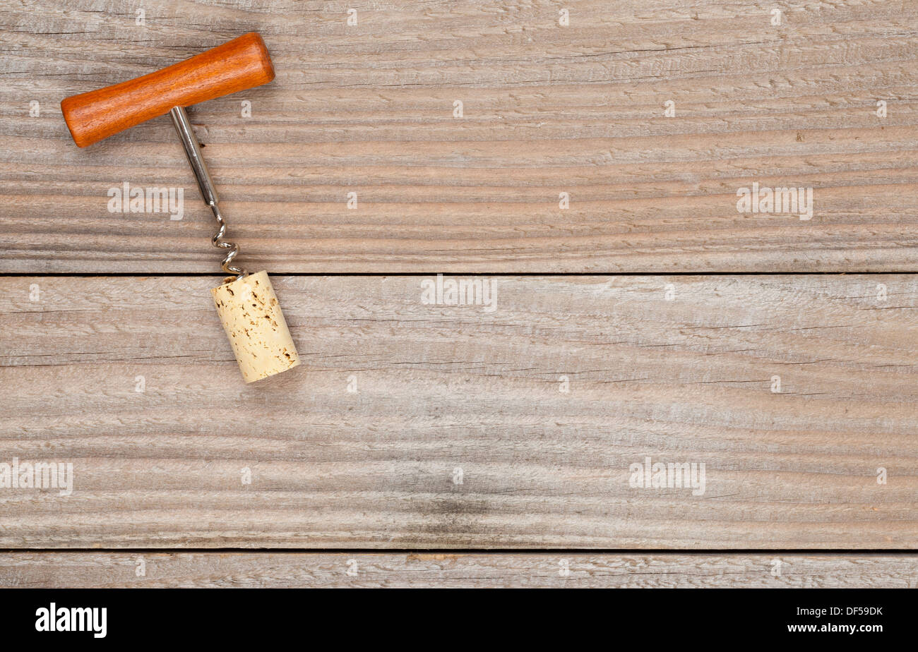 Corkscrew with wine cork on wooden planks Stock Photo