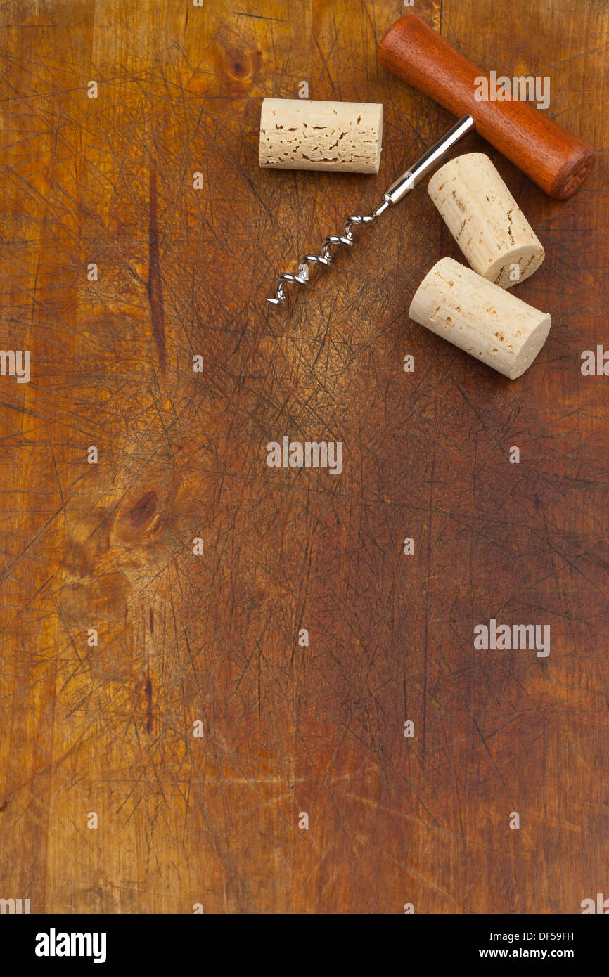 Corkscrew and wine corks on wooden background Stock Photo