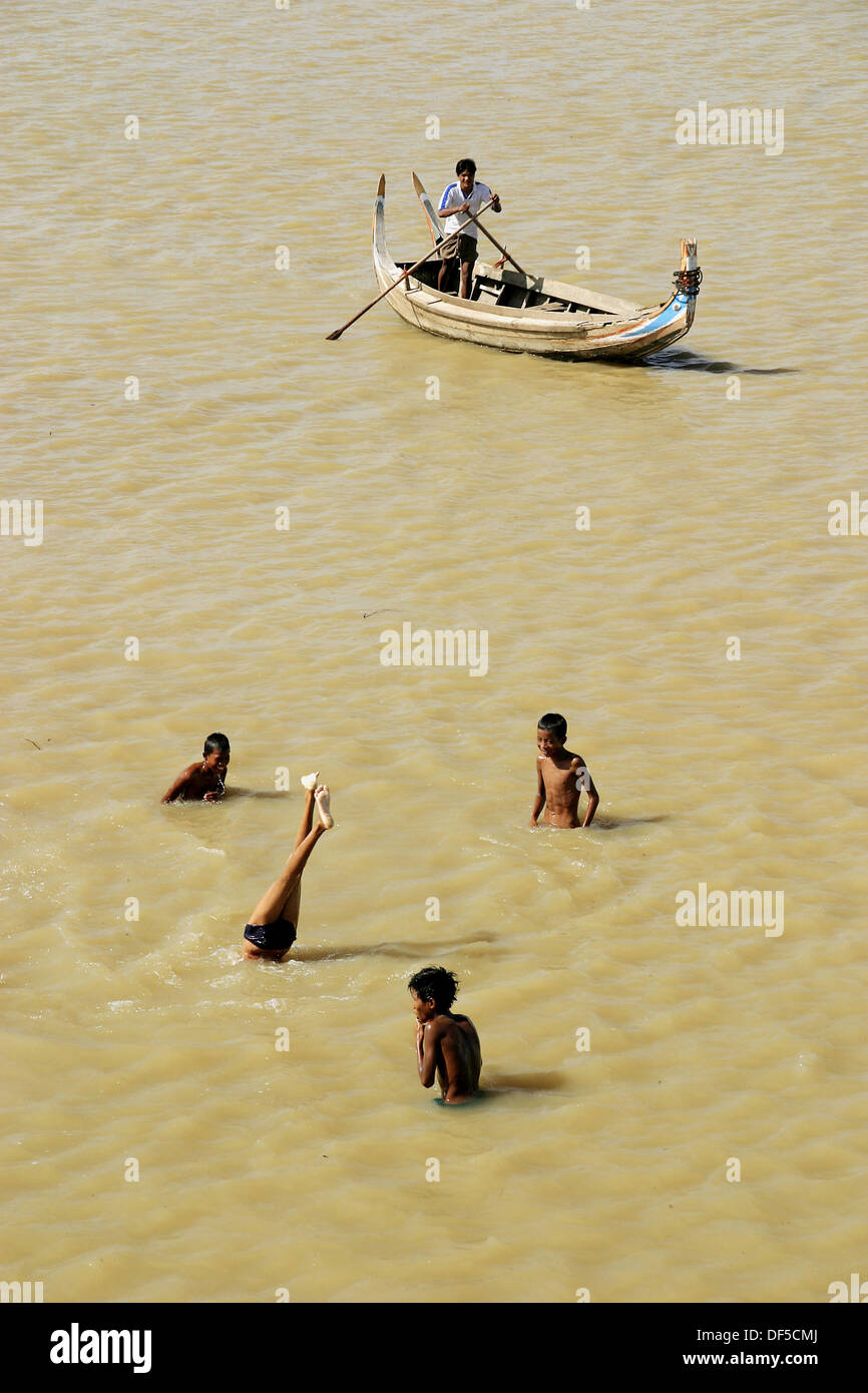 Boys playing and canoe. Thaungthaman Lake. Amarapura. Mandalay Division