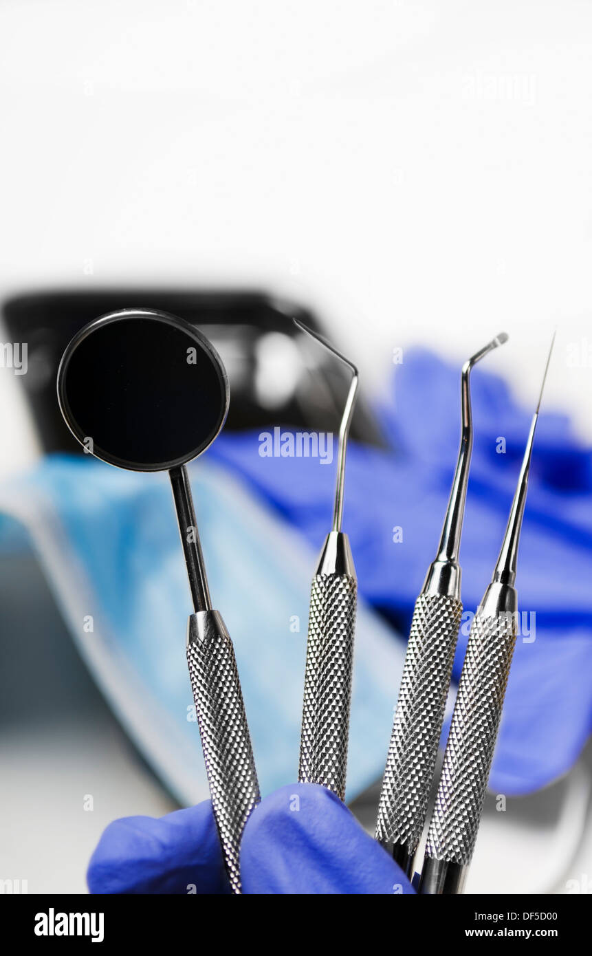 Gloved dentist hand holding dental instruments Stock Photo - Alamy