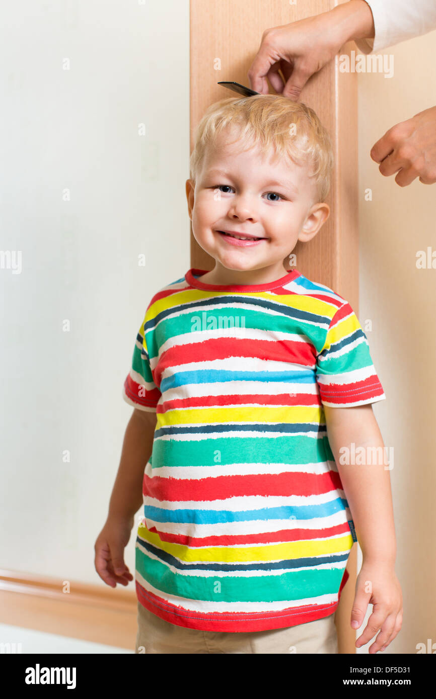 Mother measuring height of child boy Stock Photo