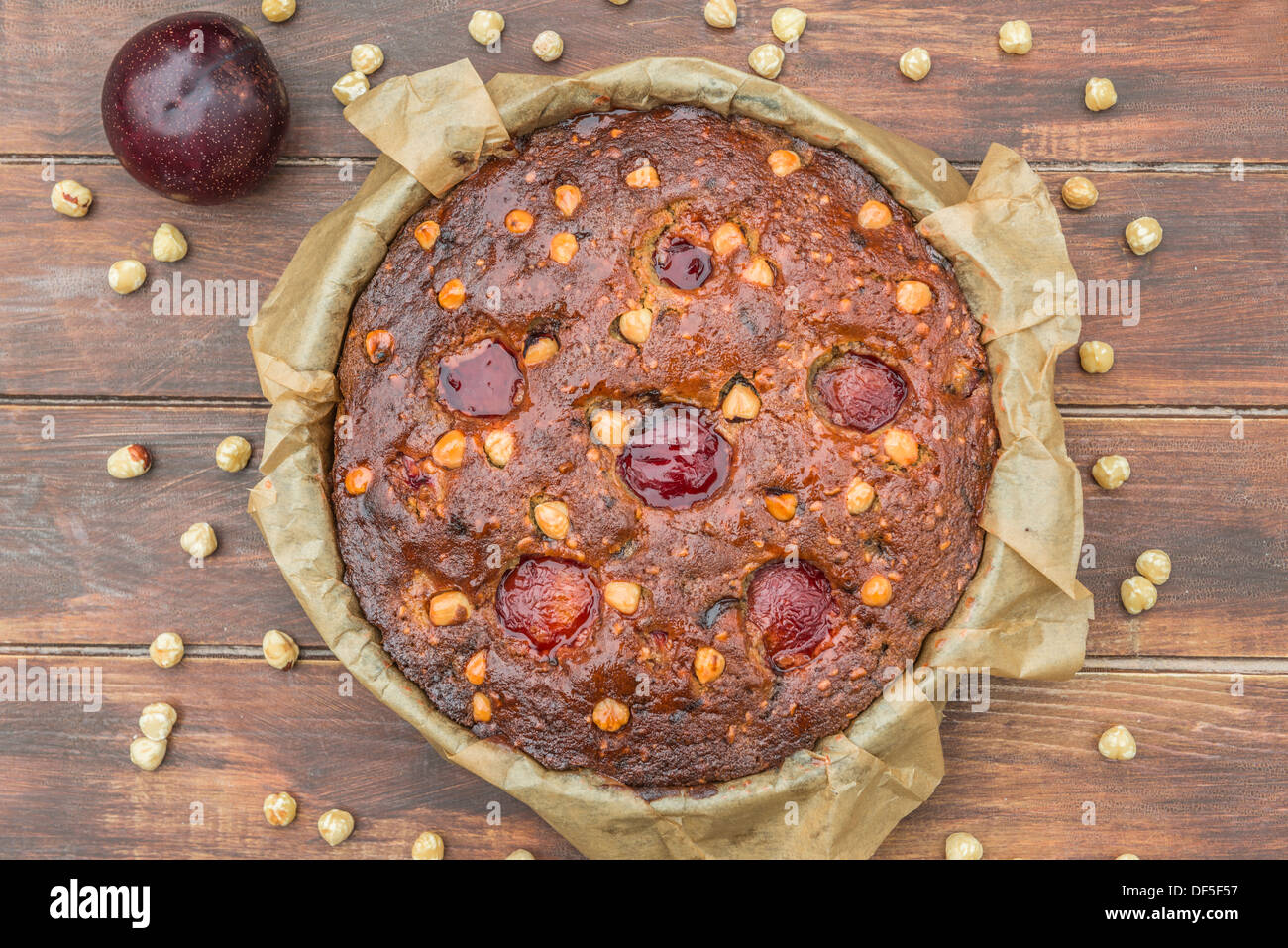 Plum, hazelnuts and chocolate home baked cake glazed with fruit jelly Stock Photo
