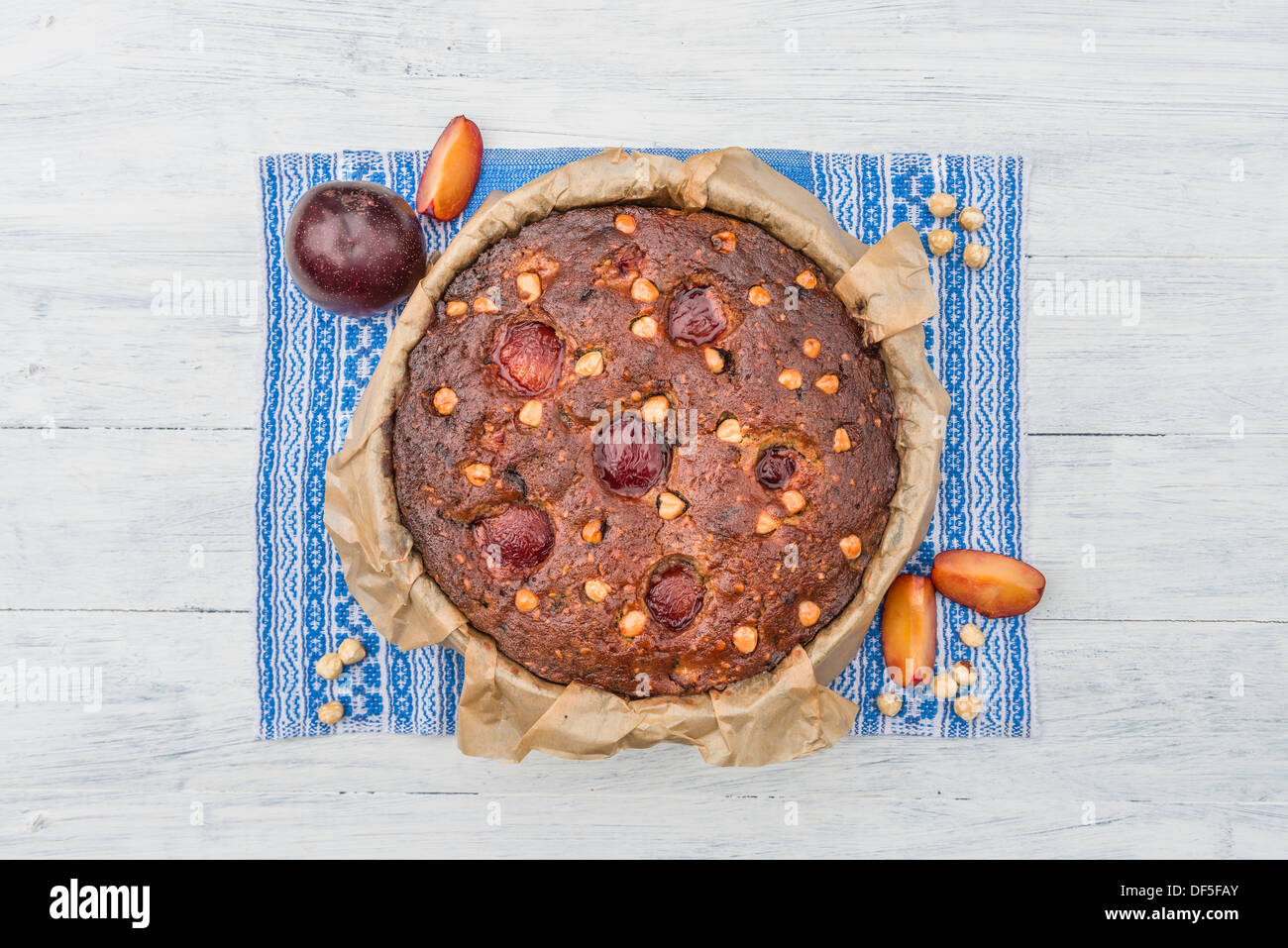 Plum, hazelnuts and chocolate home baked cake glazed with fruit jelly Stock Photo