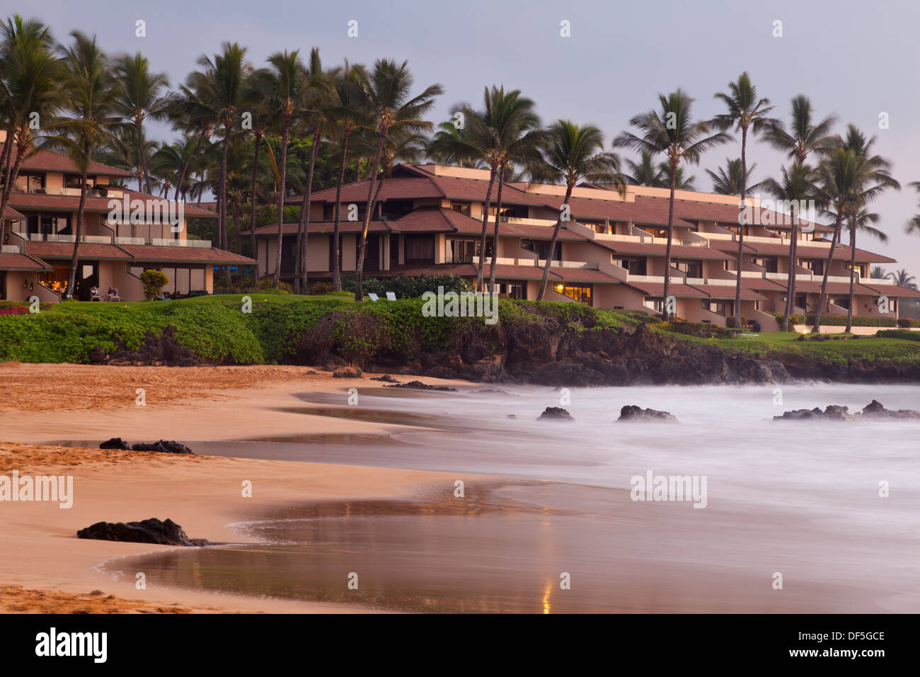 Long exposure sunset at Kamaole Beach in Maui, Hawaii with a hotel in the background. Stock Photo