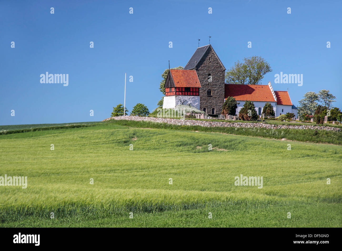 Green fields by the Ruts Kirke church on Bornholm, Denmark Stock Photo