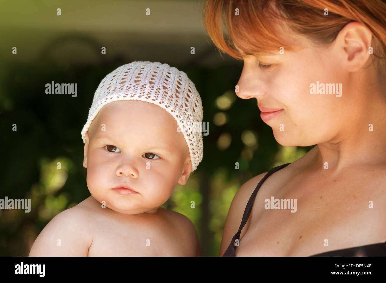 Young Caucasian mother with her baby girl in summer garden Stock Photo