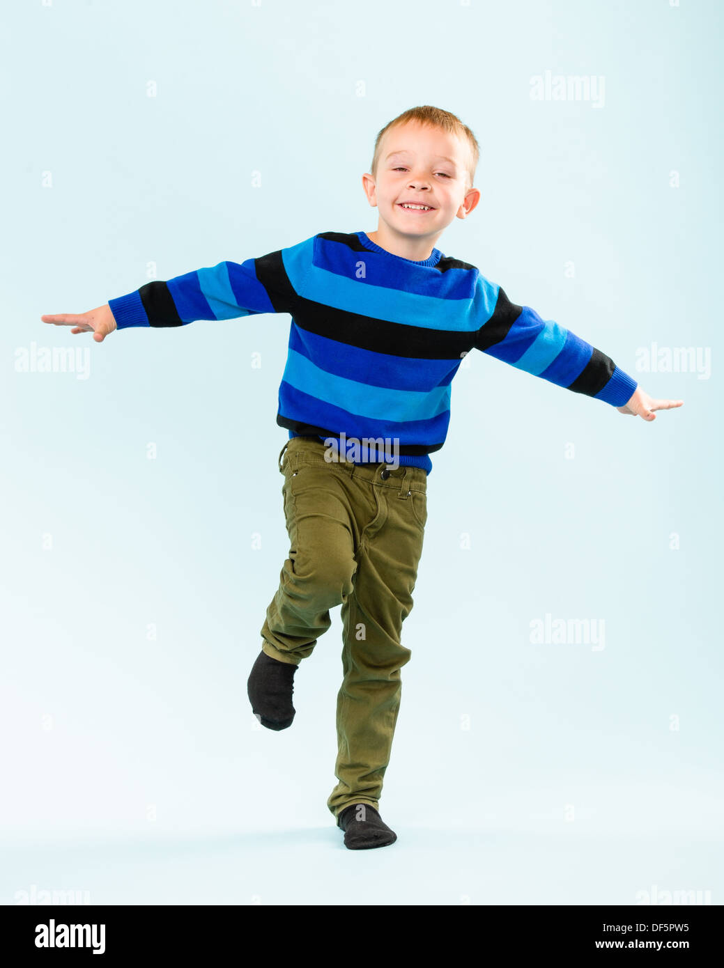 Playful little boy on studio, light blue background Stock Photo - Alamy