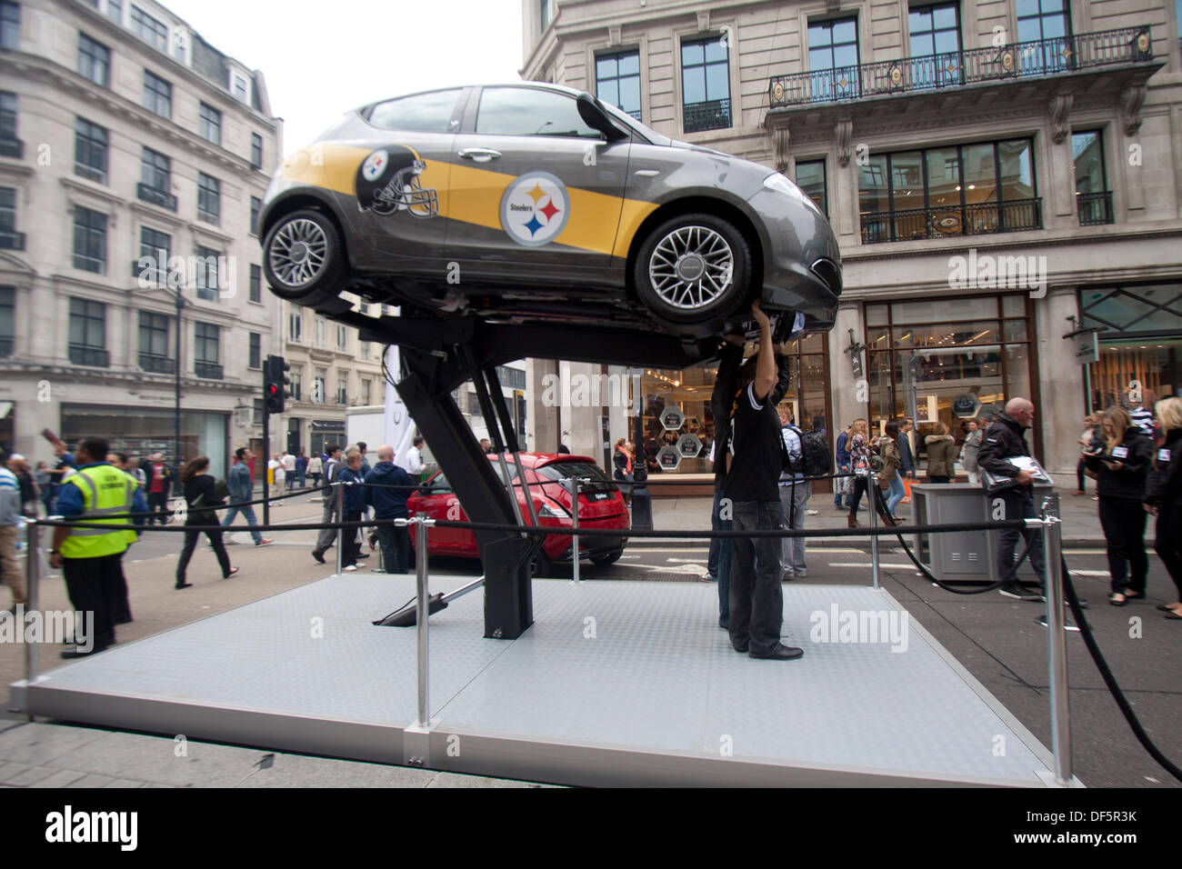 London, UK. 28th Sep, 2013. 28th September 2013. London UK. Fans pretend to lift a Pittsburgh Steelers promotion car as thousands of fans attend an American style block party in Regents street ahead of the NFL game between the Minnesota Vikings and Pitsburgh Steelers which will be played at Wembley stadium on sunday september 29. Credit:  amer ghazzal/Alamy Live News Stock Photo