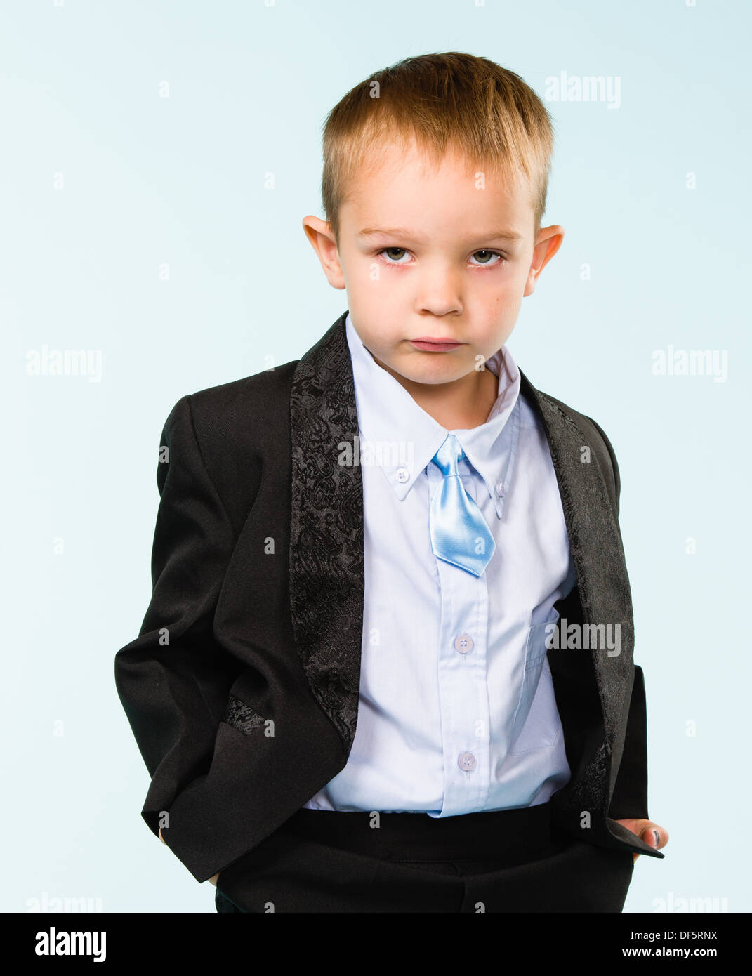 Handsome little boy posing on studio, light blue background Stock Photo ...